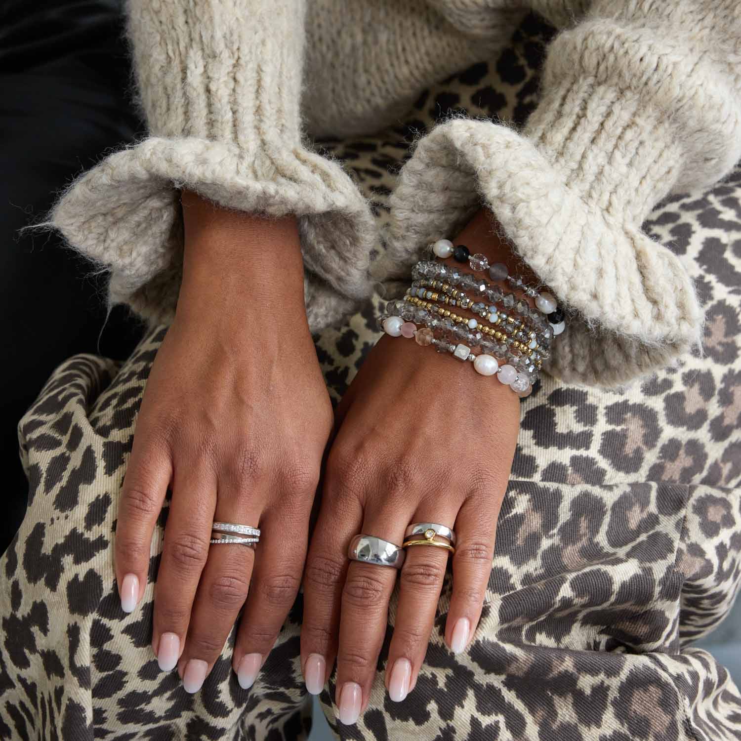 Frau traegt Ring CLAIRE 18 mit Armbändern und Ringen an der Hand