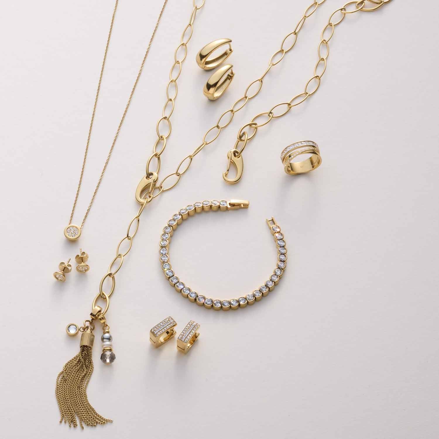 Goldene Schmuckkollektion mit Halsketten, Armbändern, Ringen und Ohrringen auf weißem Hintergrund