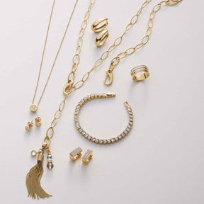 Goldene Schmuckkollektion mit Halsketten, Armbändern, Ringen und Ohrringen auf weißem Hintergrund