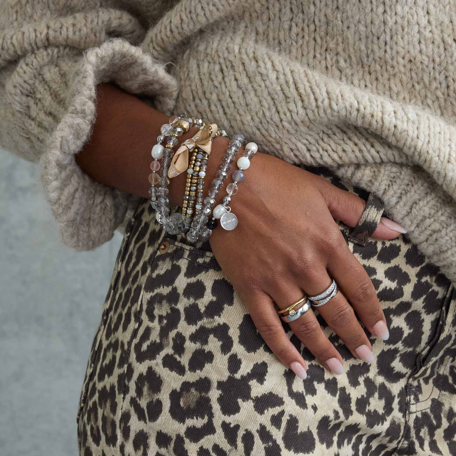 Frau traegt Ring SARAH 17 silber an der Hand mit Armbaendern