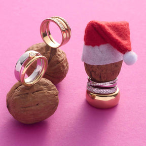 Ringe SARAH 18 auf Walnüssen neben weihnachtlicher Dekoration auf rosa Hintergrund