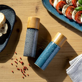 Gewürzmühlen MATERA in anthrazit auf Holztisch mit Caprese-Salat und Gewürzen