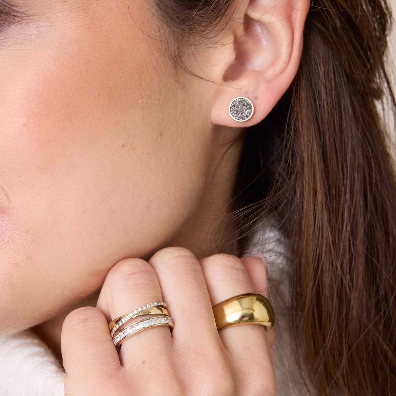 Frau traegt Ring SARAH 19 gold an der Hand, dazu Ohrstecker und weitere Ringe
