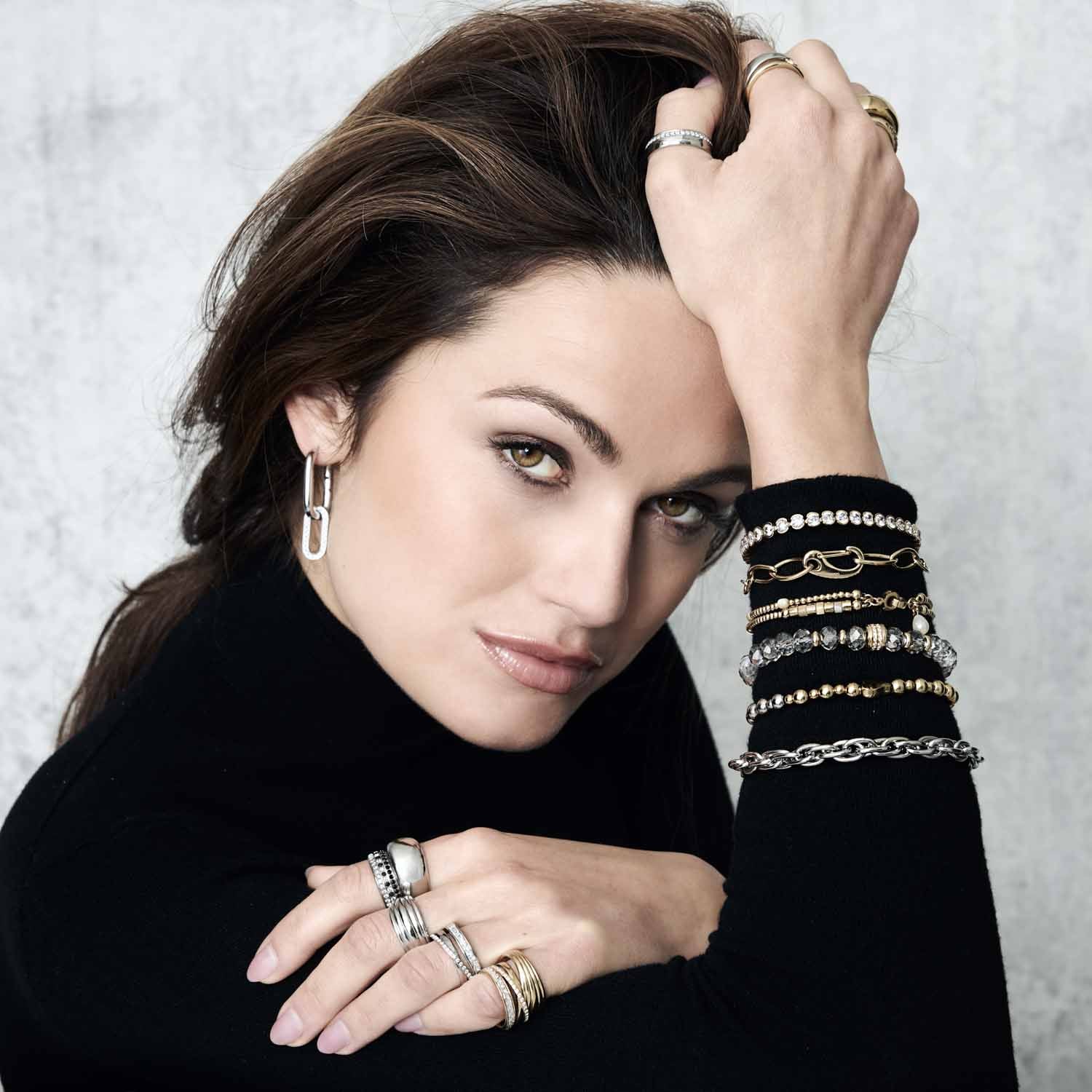 Frau traegt Ring SARAH 19 gold an der Hand, mehrere Armbänder sichtbar