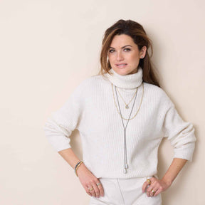 Frau trägt weiße Strickjacke mit goldener Halskette NINON Clip & Mix