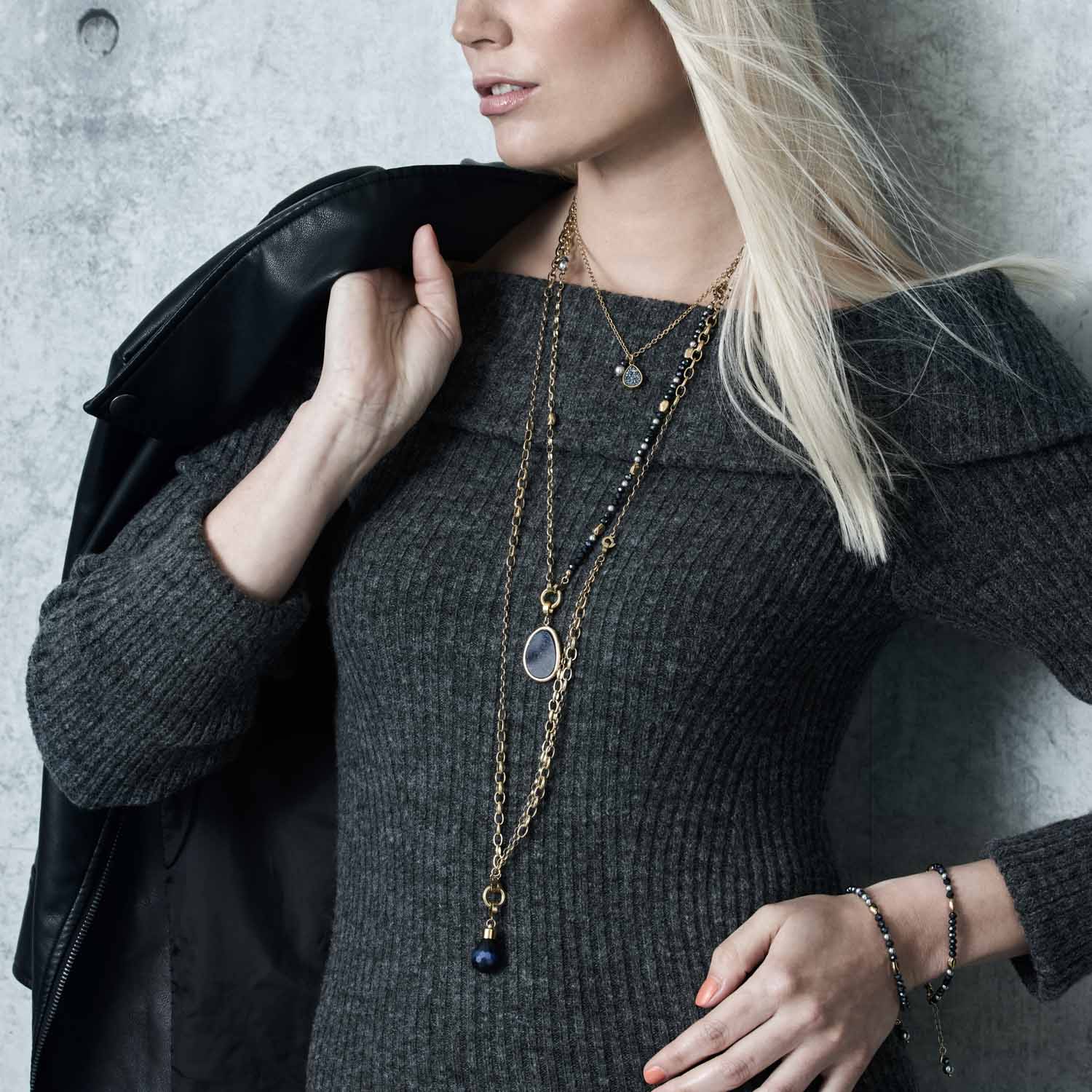 Frau traegt Halskette CHARLENE 50 cm gold mit Glasanhaengern, schwarze Jacke, Armband