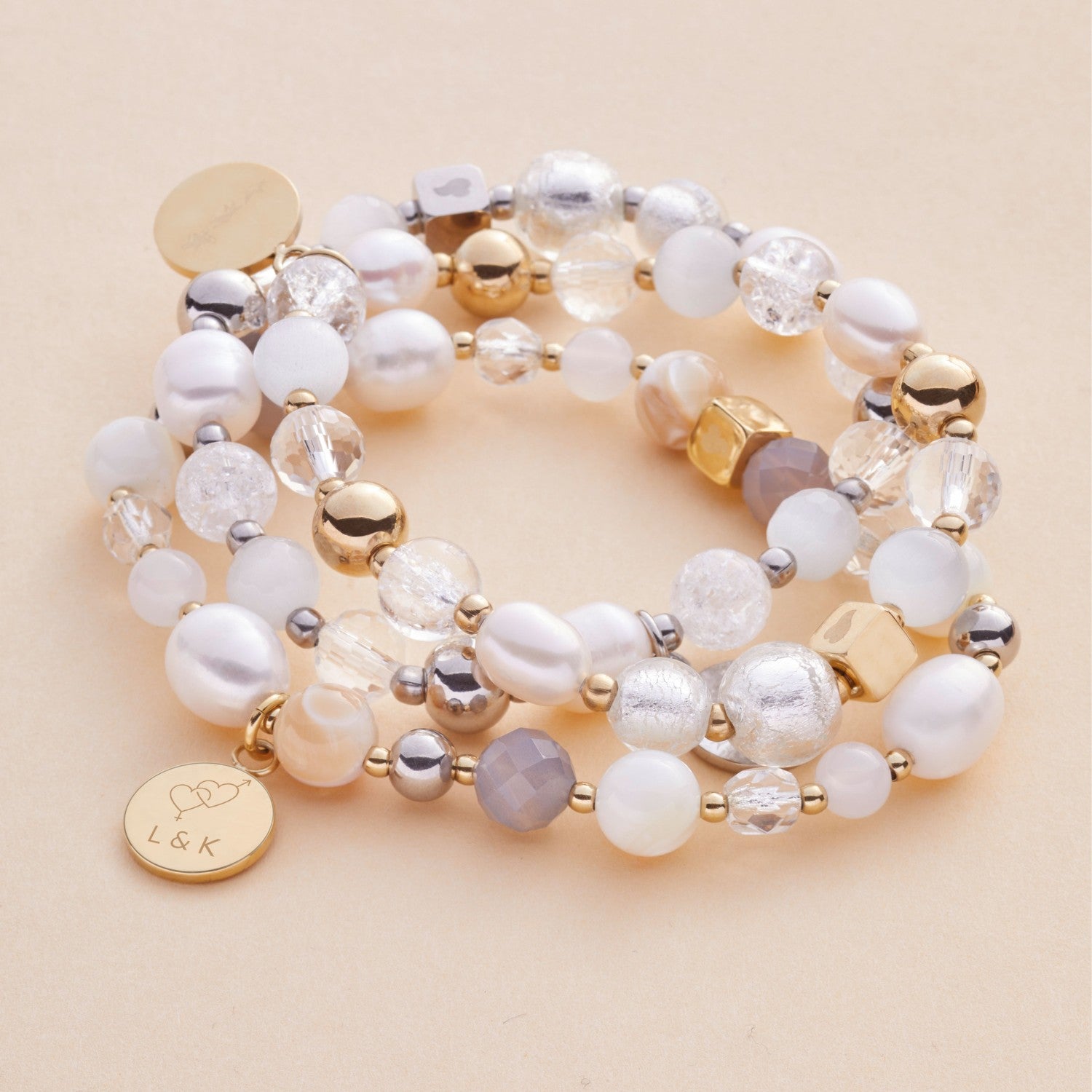 Armband HOPE gold mit Glasperlen, Metallperlen und Gravur auf beigefarbenem Hintergrund