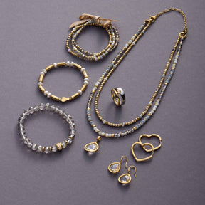 Schmuckkollektion aus Glas mit Armbändern, Kette und Ohrhängern in Gold und Weiß