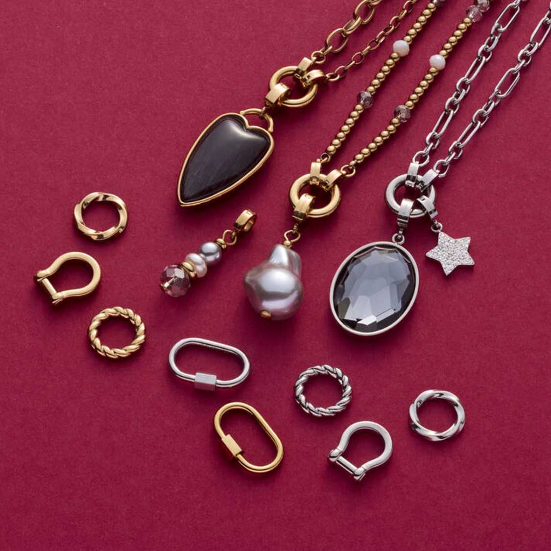 Edelstahlring LOTTI Clip & Mix mit Halsketten und Charms auf pinkfarbenem Hintergrund