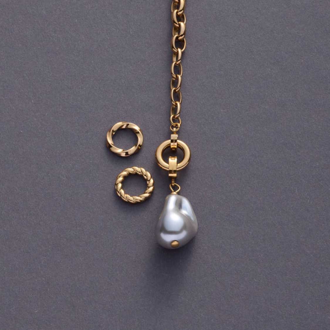 Goldene Kette mit Ring LIESEL, Perlenanhänger und Verbindungselementen auf grauem Untergrund