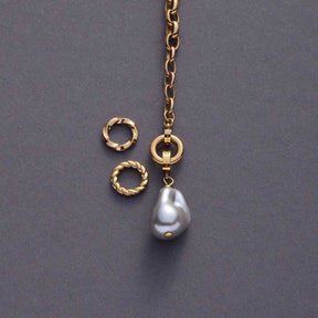 Goldene Kette mit Ring LIESEL, Perlenanhänger und Verbindungselementen auf grauem Untergrund