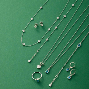 Silberner Schmuck auf grünem Hintergrund: Ohrstecker LISETTE CIAO, Ketten und Ringe