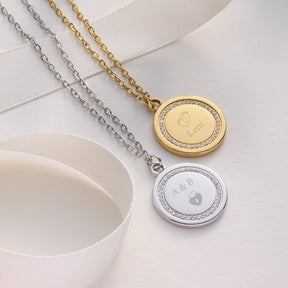 Zwei Halsketten FERRARA mit runden Gravur-Anhängern in Gold und Silber auf weißem Textil