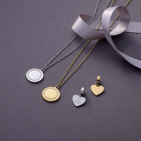 Halskette FERRARA in Gold und Silber mit runden Anhängern und Herzanhänger auf grauem Untergrund