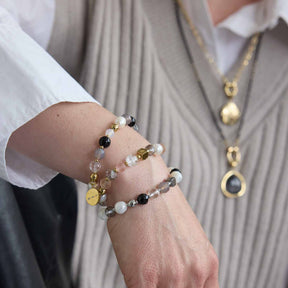 Armband HOPE gold/grau an Frauenhand getragen, mit Perlen und Metallakzenten