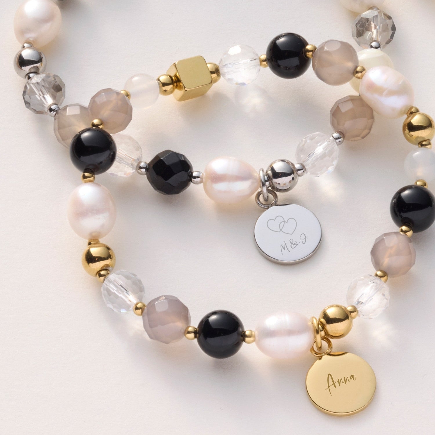 Armband HOPE gold/grau mit gravierten Anhängern auf weißem Hintergrund