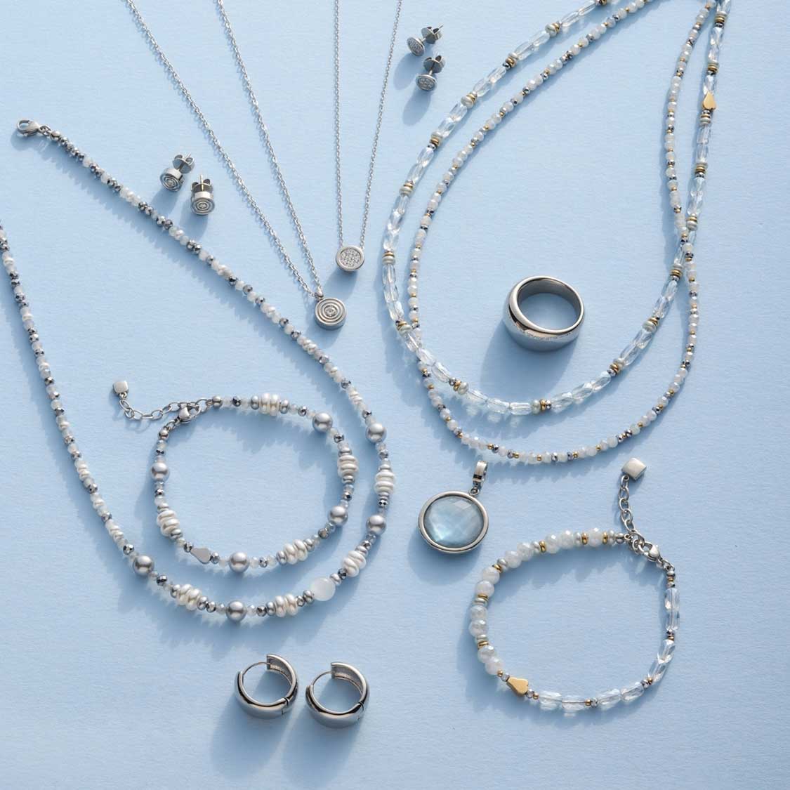 Schmuckkollektion mit Armbändern, Halsketten, Ringen und Ohrringen in Silber und Perlmutt