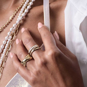 Ring LISBETH 19 gold an Hand mit Perlenketten und weißem Stoff
