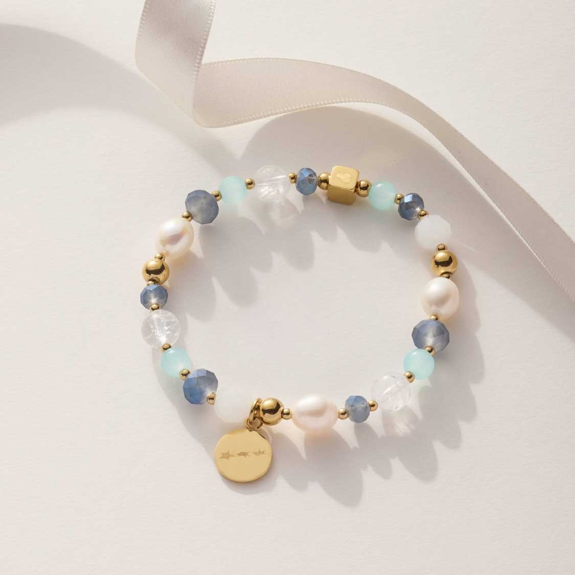 Armband HOPE gold/blau mit Perlen und goldenem Anhänger auf weißem Untergrund