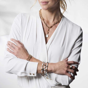 Frau traegt Armband HOPE gold/blau an Handgelenk, weisses Hemd