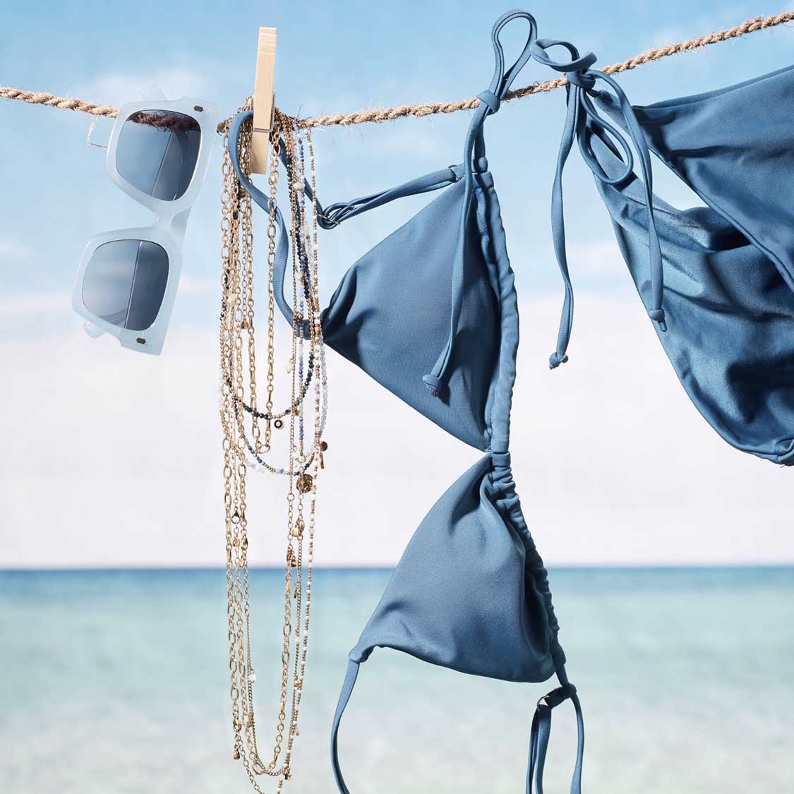 Armband SOLVANI gold CIAO an Wäscheleine mit Bikini und Sonnenbrille am Strand