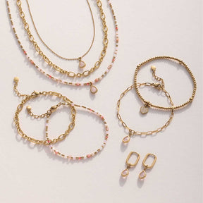 Armbänder und Ohrringe der Serie SHARI gold in Weiß, Rosa und Gold auf hellem Untergrund