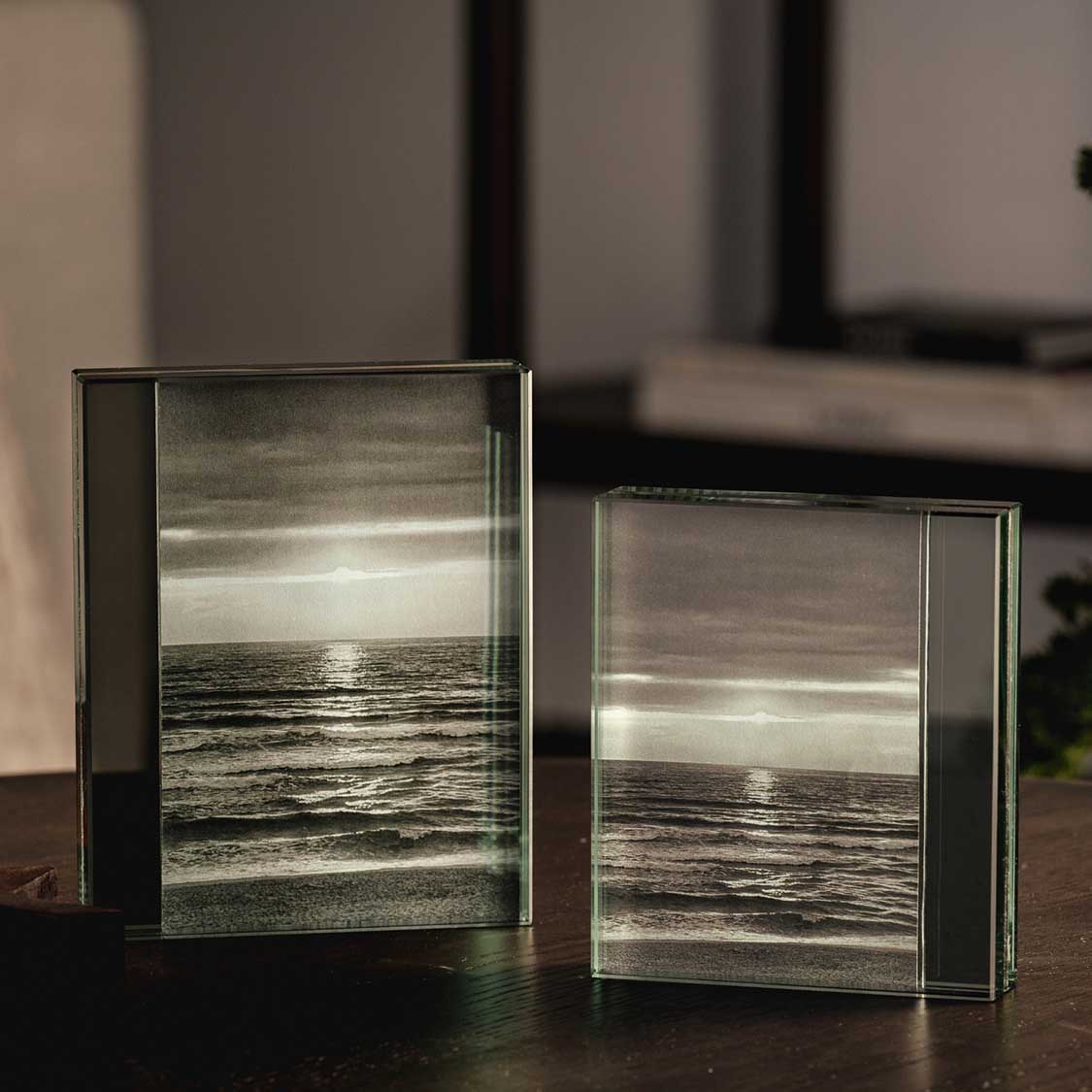 Zwei Glasbilderrahmen LINEA mit Meeresfoto auf dunklem Tisch