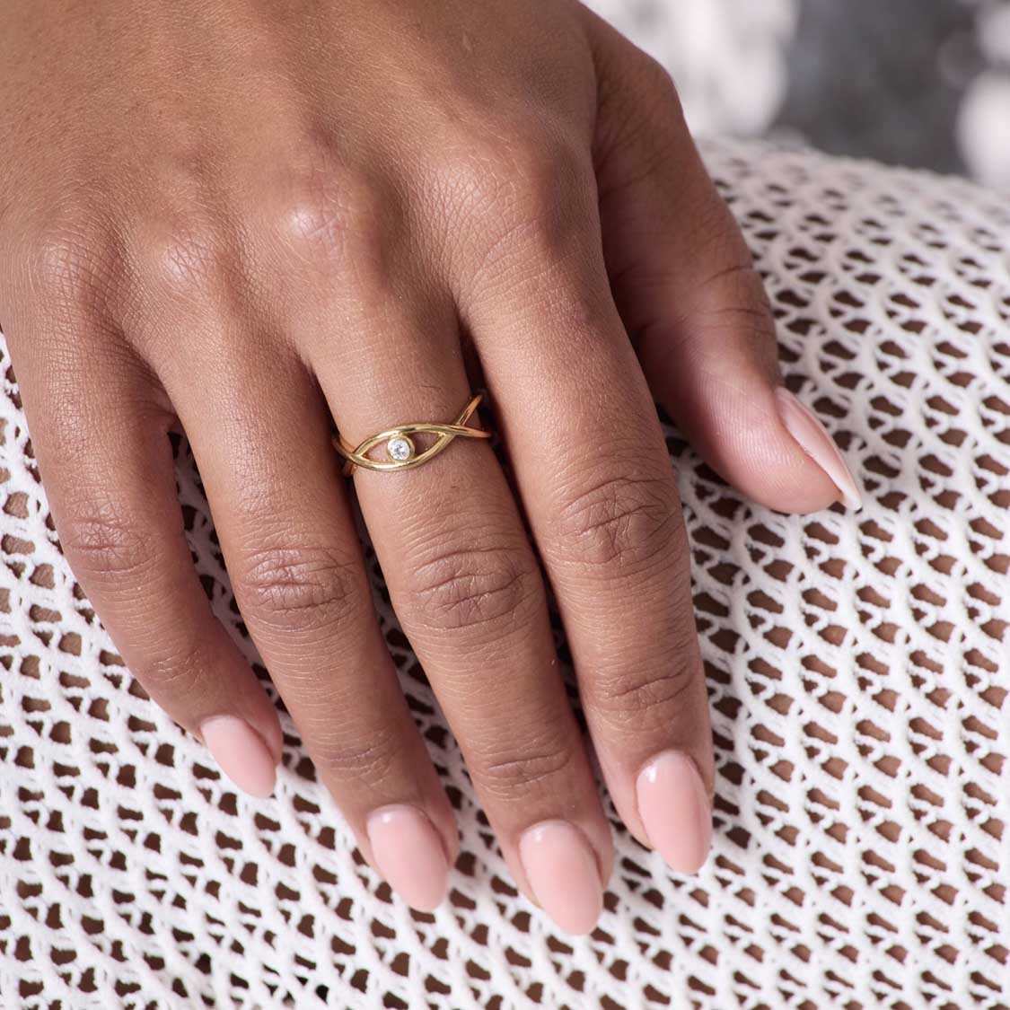 Ring TAVARI gold an Frauenhand mit rosa Nagellack, auf Spitzenstoff