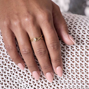 Ring TAVARI 18 gold an Hand einer Person auf Textilstoff