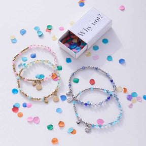 Armband AMITA You & Me CIAO mit bunten Perlen, Verpackung und lose Perlen auf weißem Hintergrund
