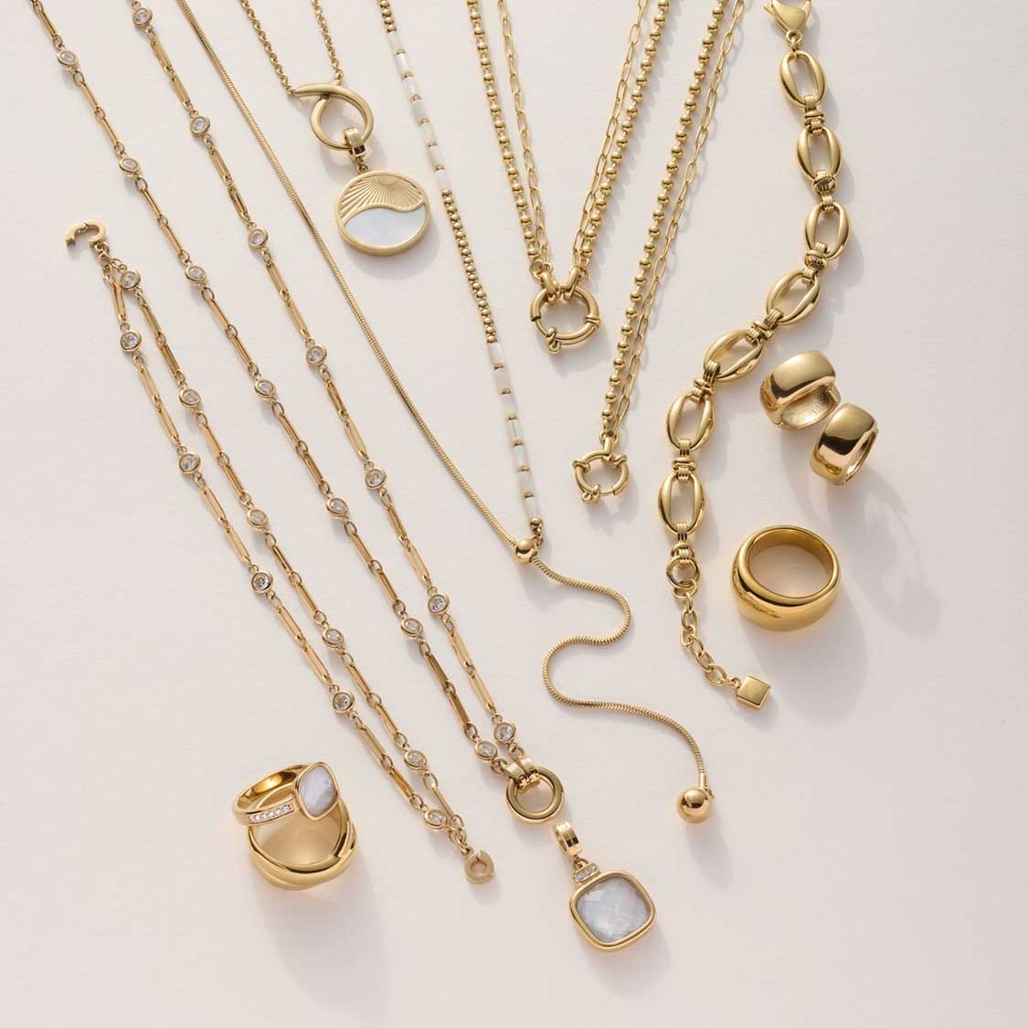 Goldene Halsketten und Ringe in verschiedenen Designs und Längen arrangiert