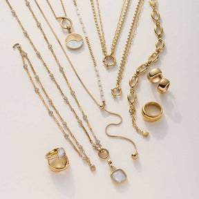 Goldene Halsketten und Ringe in verschiedenen Designs und Längen arrangiert