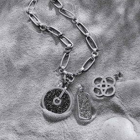 Anhänger EDITH Clip & Mix an Kette auf grauem Textilhintergrund mit Schmuckdetails
