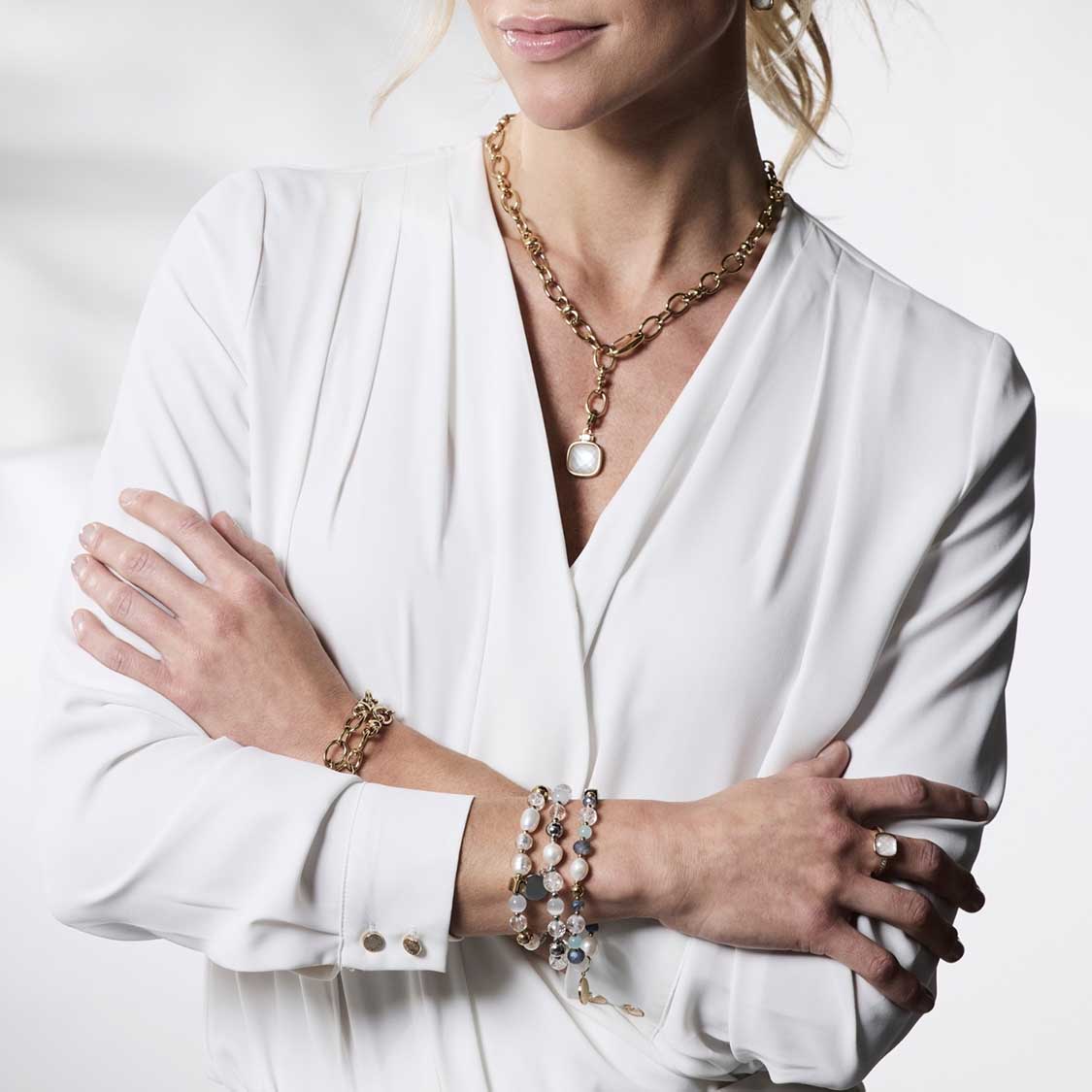 Frau trägt goldenen Ring VIRGINIA 19 mit Armschmuck und Halskette