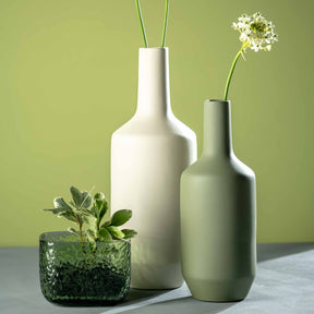 Keramikvase MILANO mit Blumen und Pflanzen auf grauem Untergrund vor grünem Hintergrund