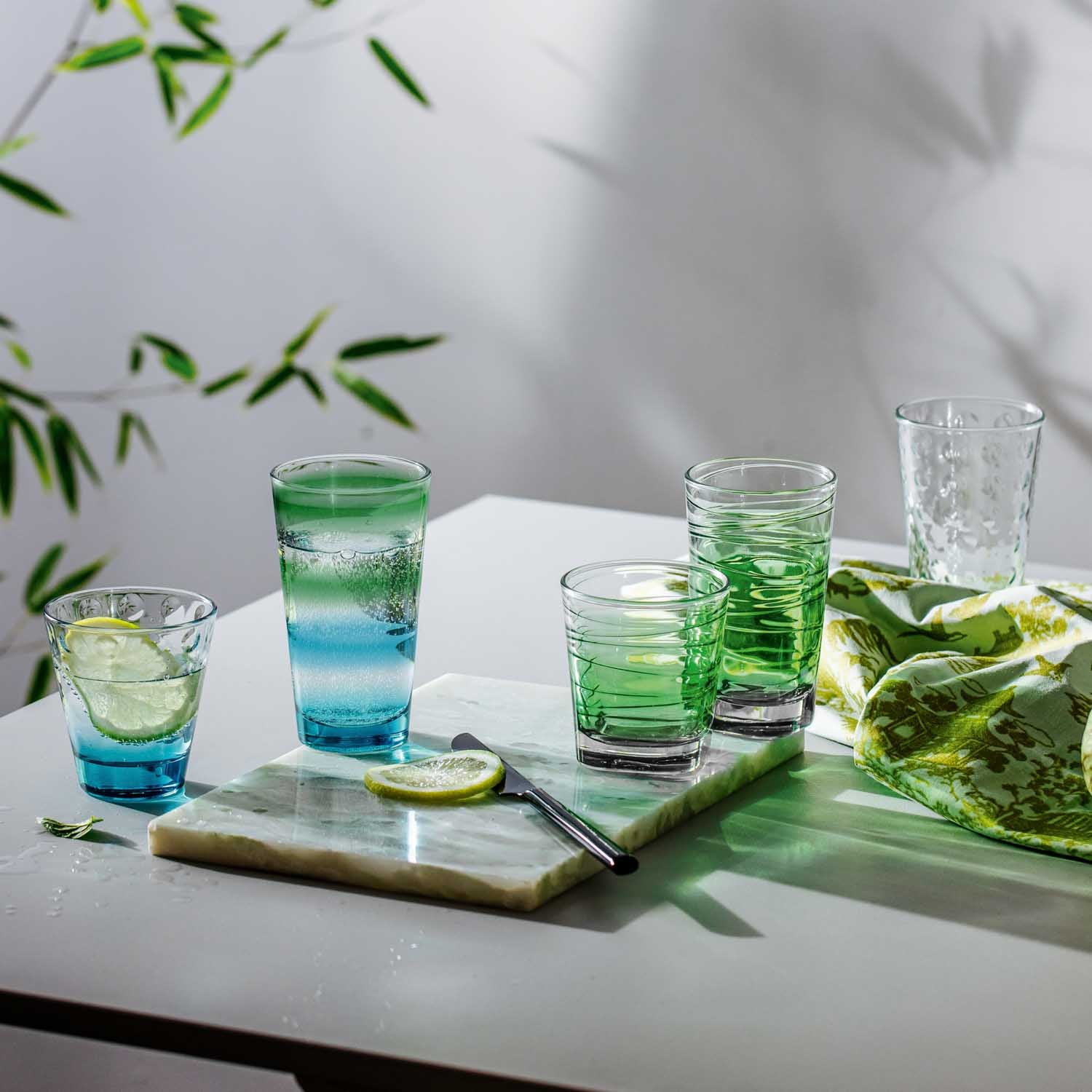 Trinkglas VARIO STRUTTURA auf Tisch mit Limette und grünen Blättern arrangiert