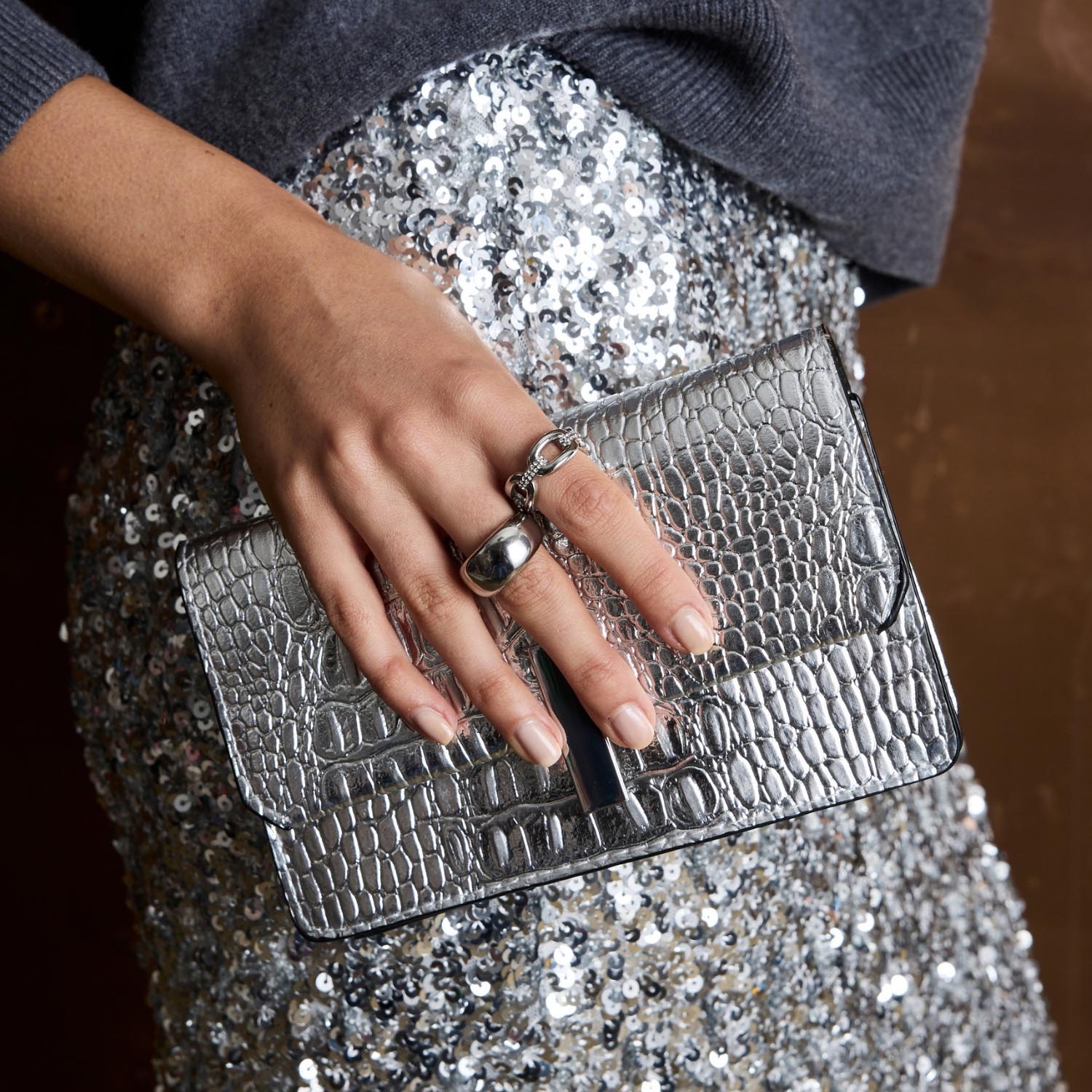 Ring BELLE 19 an Hand mit Clutch und Pailletten-Top