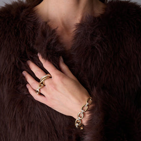 Frau traegt Ring BELLE 17 gold an der Hand, darunter Armband und Pelzstola