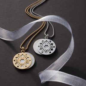 Zwei goldene und silberne Halsketten mit rundem Anhänger und ornamentalem Muster auf grauem Hintergrund