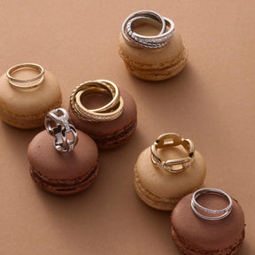 Ring TINI 20 CIAO auf Makronen in Beige- und Brauntönen arrangiert