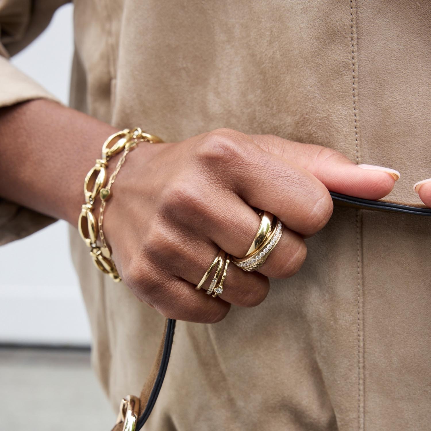 Hand trägt goldenen Ring TINI 17 mit Armband und Kette
