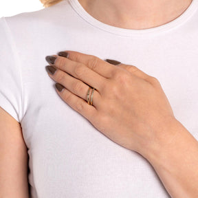 Frau traegt goldenen Ring TINI 19 an der Hand auf weißem Shirt