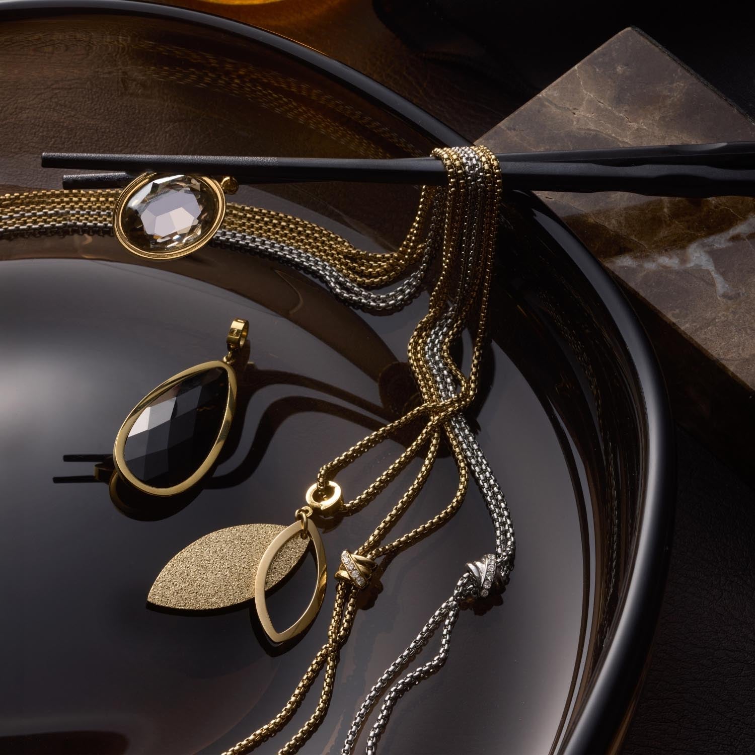 Anhänger MO Clip & Mix in Gold und Silber auf Schmuckdisplay mit Ketten