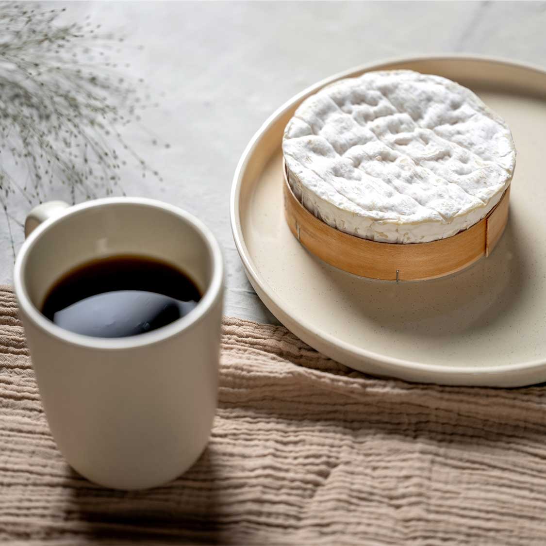 Keramiktasse ROMA mit schwarzem Kaffee, daneben Käse auf Teller