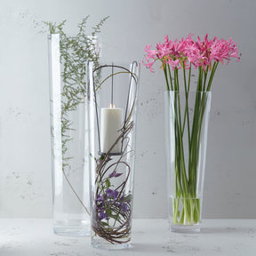 Drei Glasvasen mit Blumenarrangements auf weißem Untergrund