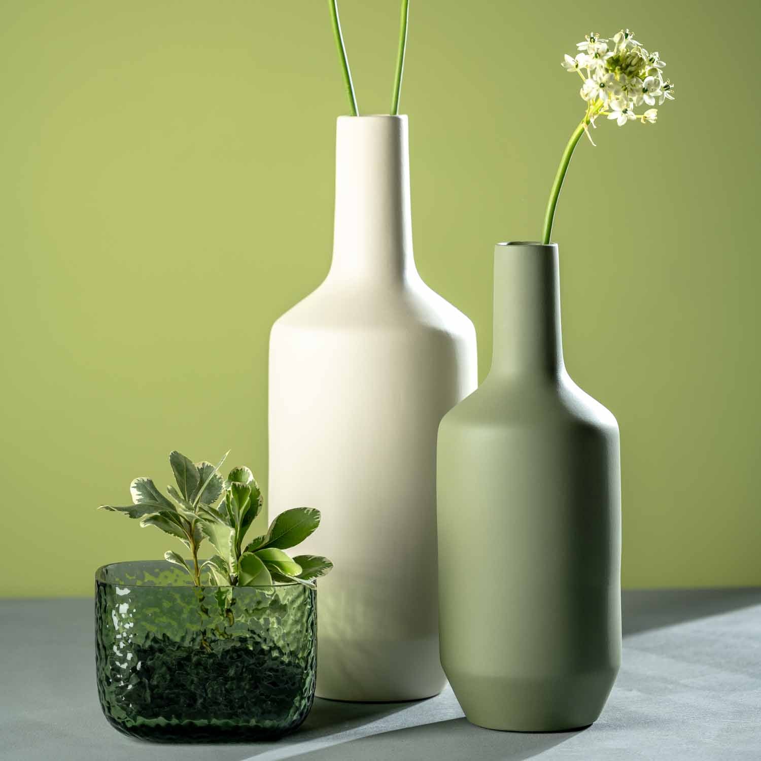 Vase MARTELLO 13 cm grün mit Dekoration auf grauem Untergrund vor grünem Hintergrund
