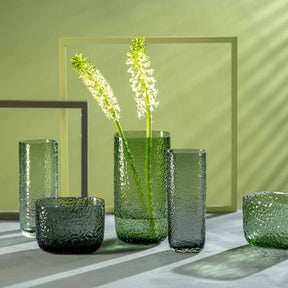 Grüne Glasvasen MARTELLO mit Blütenranken in minimalistischer Innenraumszene