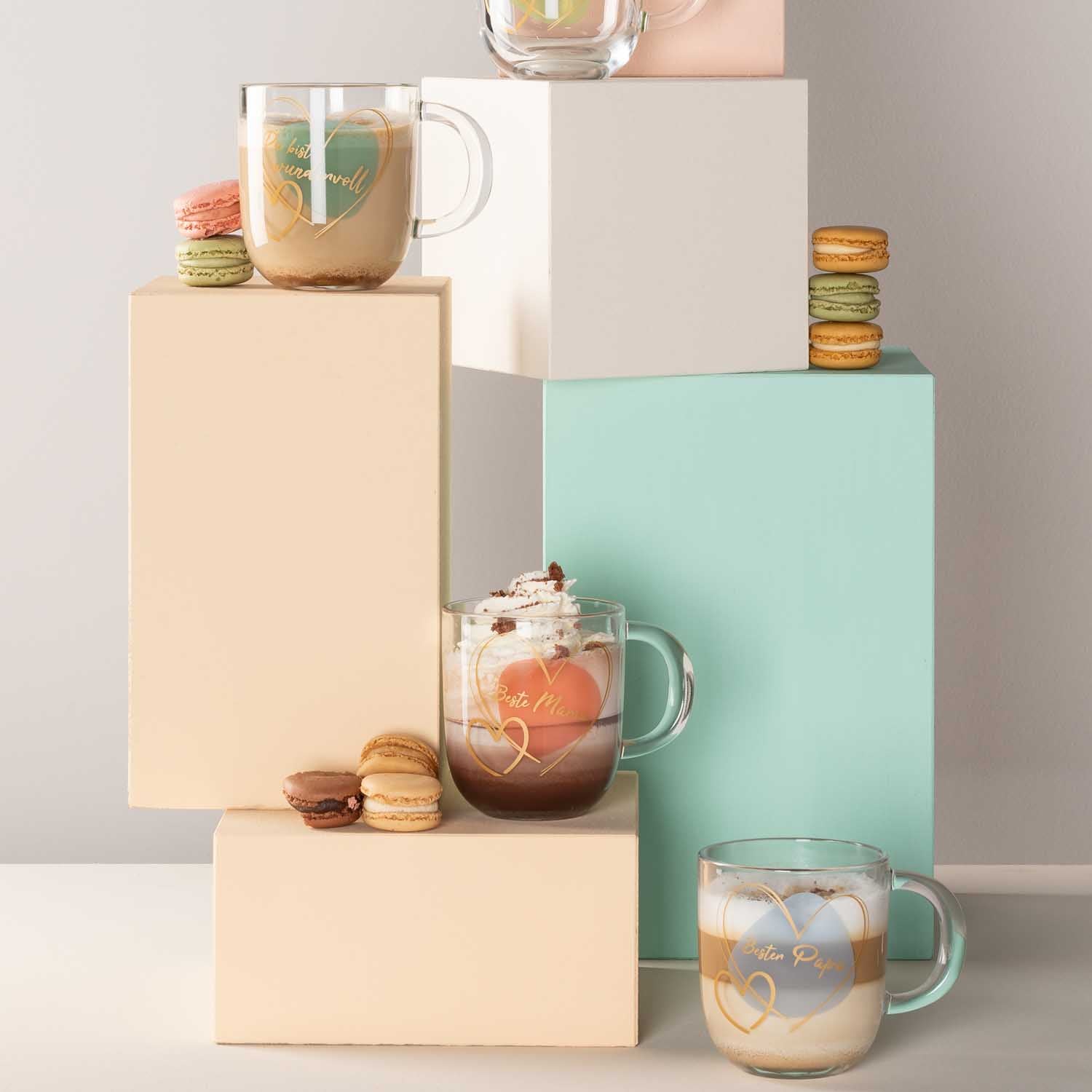Glasbecher und Getränke auf gestapelten Boxen mit Macarons