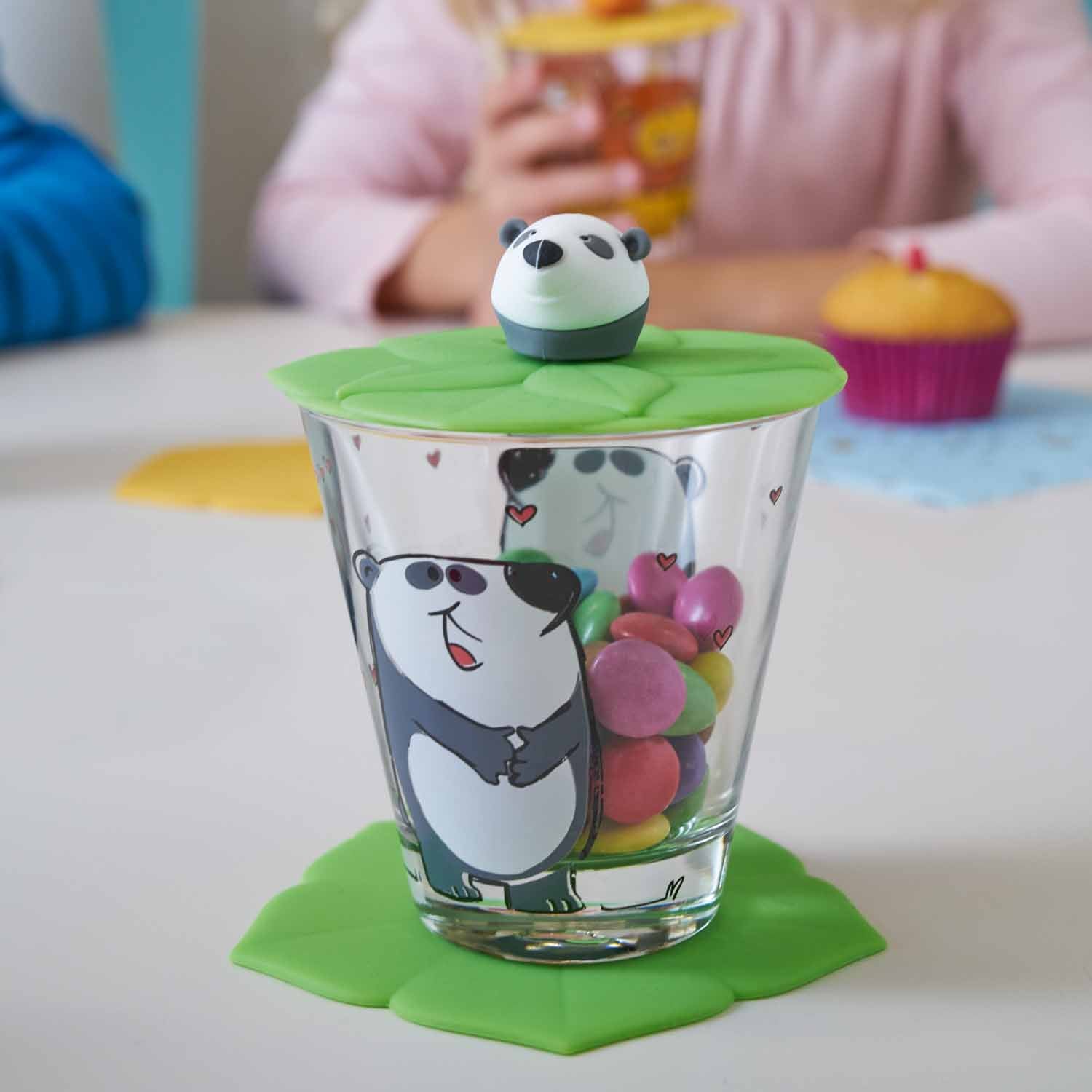 Kindertrinkset BAMBINI mit Panda-Motiv, gefüllt mit bunten Kugeln, Kind im Hintergrund mit Muffins
