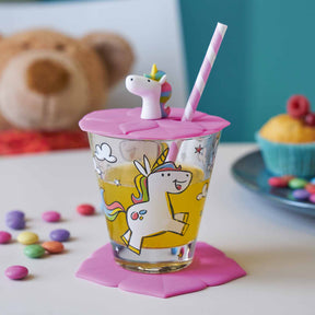 Kindertrinkset BAMBINI mit Einhorn-Motiv, rosa Deckel und Strohhalm, umgeben von Süßigkeiten und Teddy